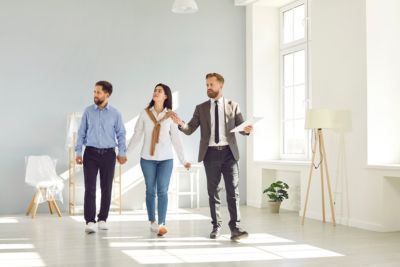 Personnes accompagnées d'un agent immobilier pour la vente de leur bien immobilier.